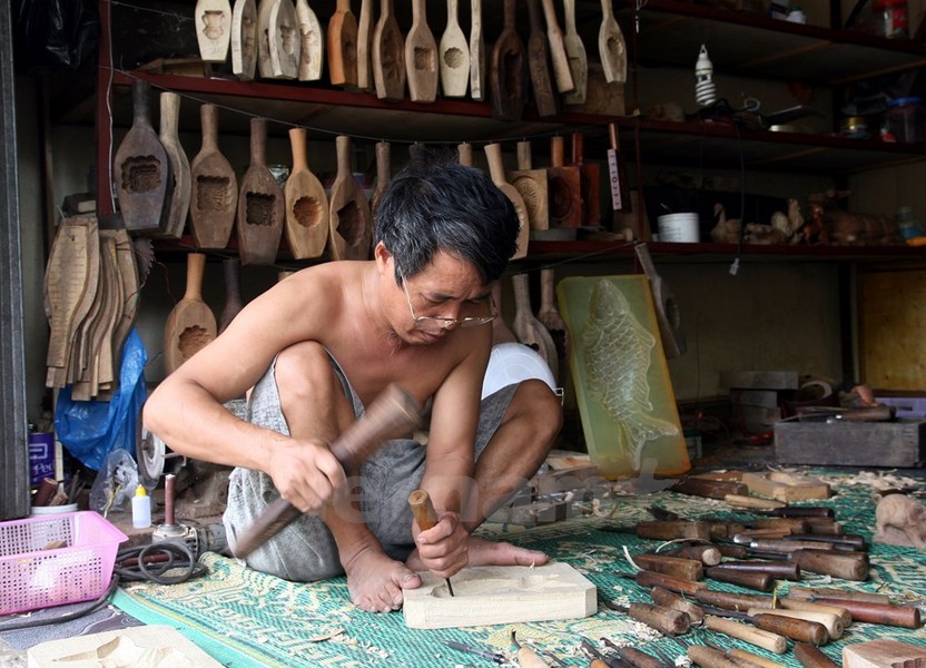 Vào những ngày này, về thôn Định Quán, bạn sẽ thấy nhiều người làm khuôn bánh, tiếng đục vang khắp nơi. Bác Trần Văn Bản là một trong những người có thâm niên với  nghề làm khuôn bánh trung thu trong thôn.(Ảnh: Doãn Đức/Vietnam+)